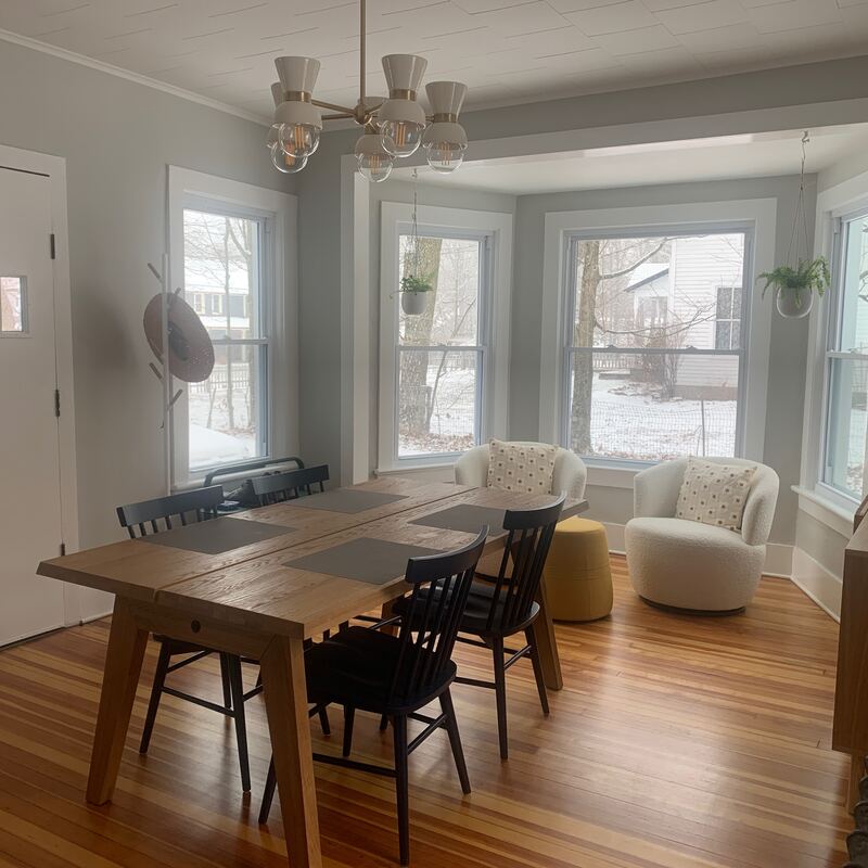 The redone dining room with a wood table and bay window