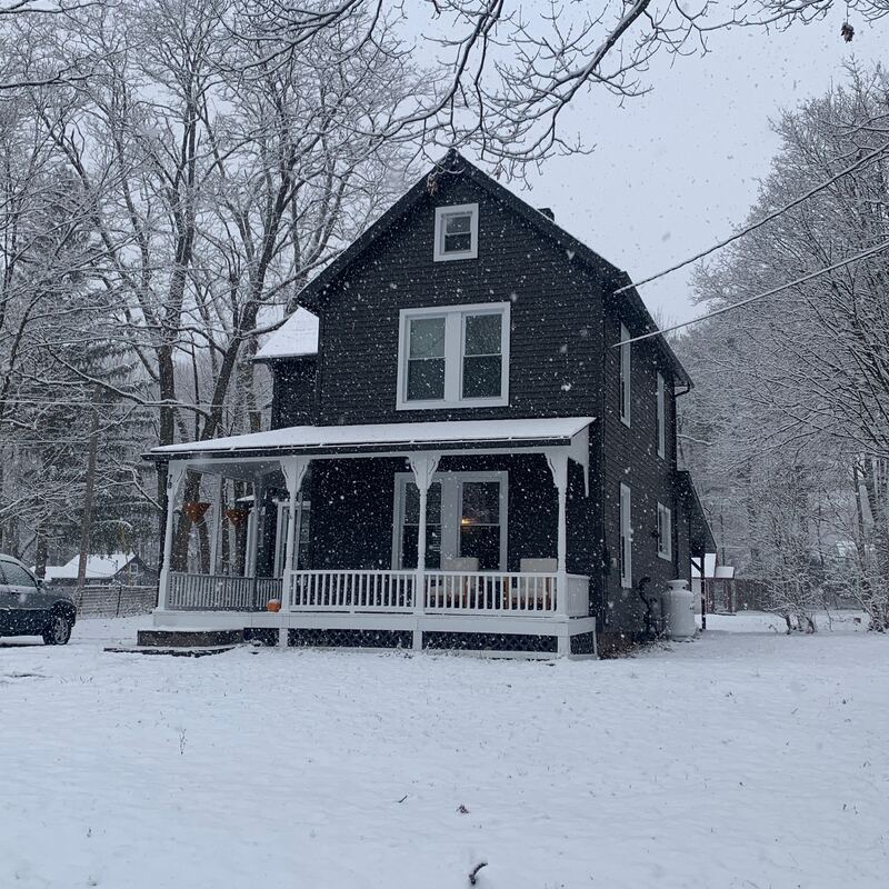 Snow falling on the house and front porch
